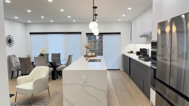 A modern kitchen with a central island, stainless steel appliances, and recessed lighting. - Lakeside Gem - Frenchman's Bay (Pickering)