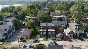 A residential area with houses, a parking lot, and a river in the background. - Lakeside Gem - Frenchman's Bay (Pickering)