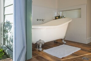A bathroom with a freestanding bathtub, a white rug, and a decorative silver vase. - Foxglove Luxury accommodation stay. Tranquil retreat in Tilba Tilba (Tilba Tilba)