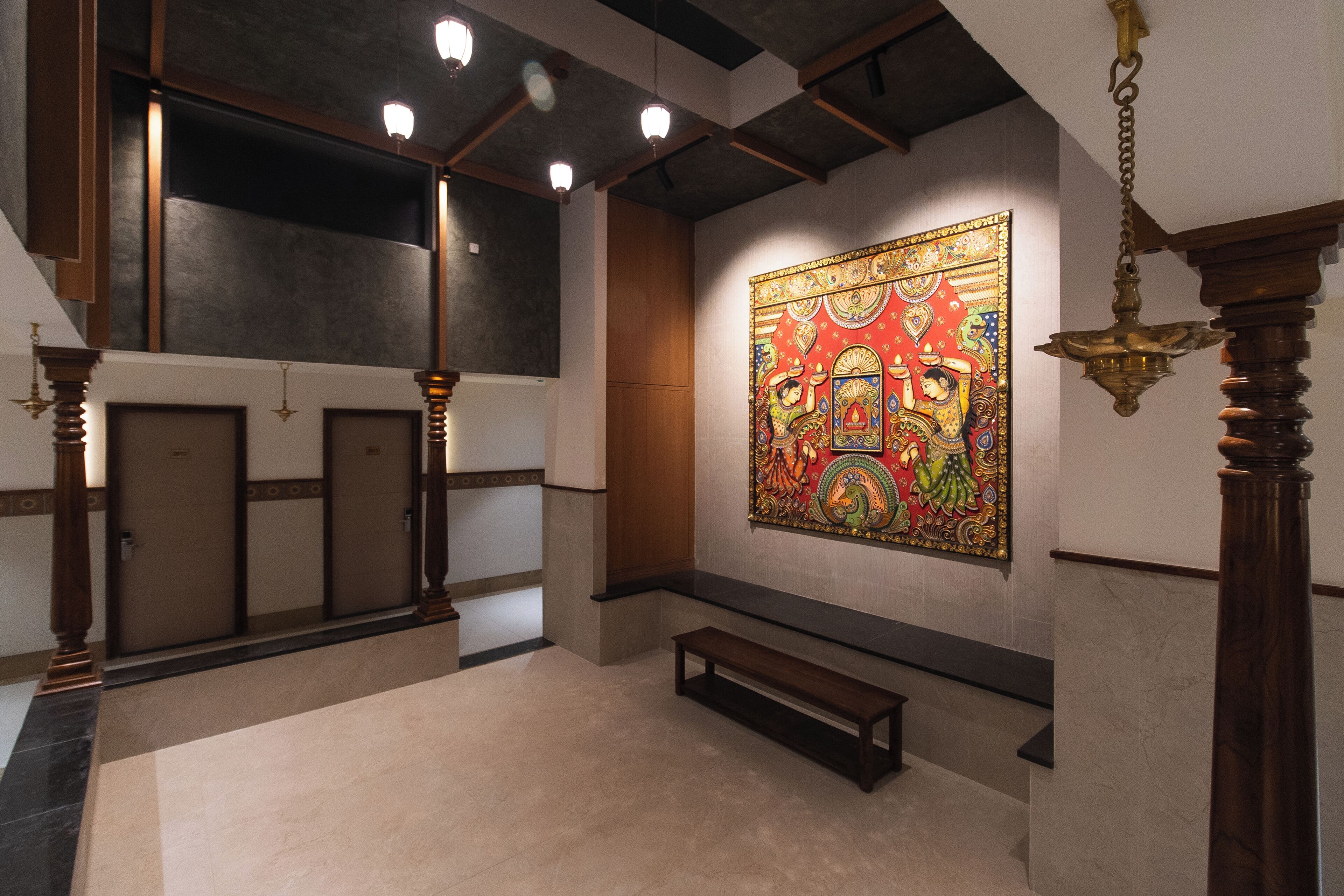 A lobby with a large colorful mural, wooden benches, and a bench with a small table.