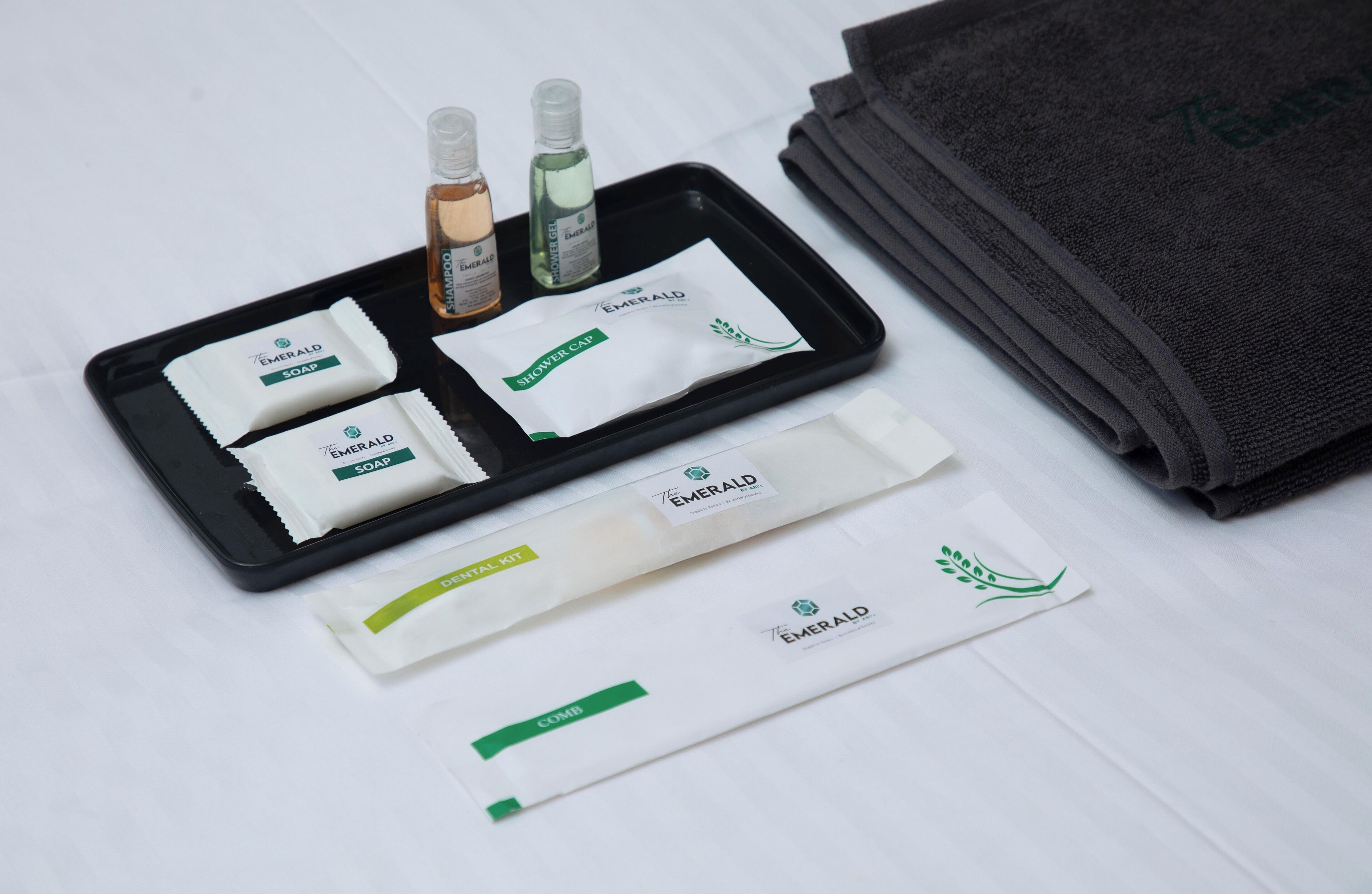 A tray with various toiletries including soap, shampoo, conditioner, and a comb.