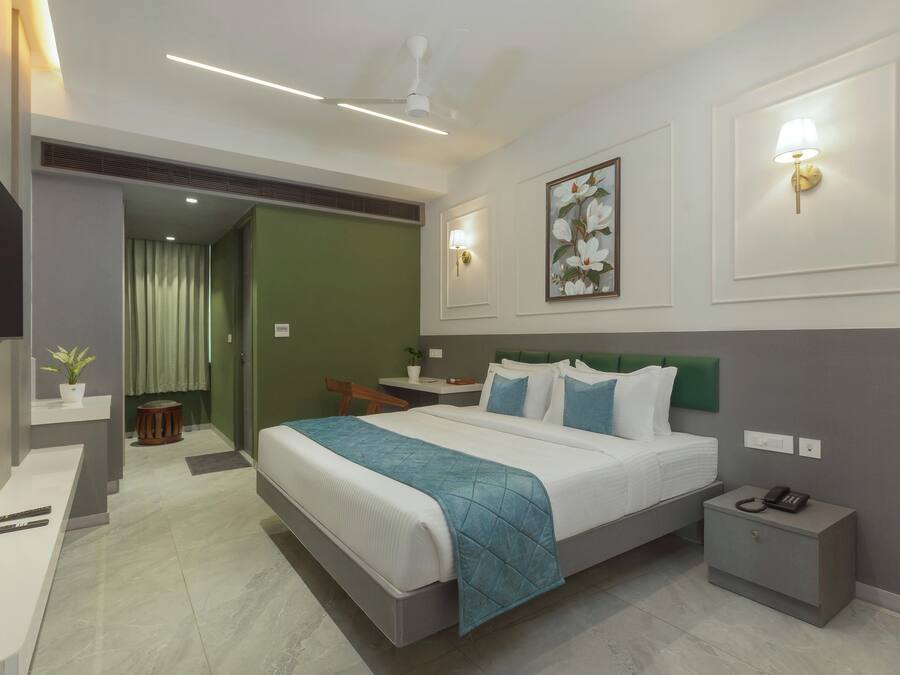 Una habitación de hotel moderna con una cama grande, mesitas de noche, un escritorio y una silla.