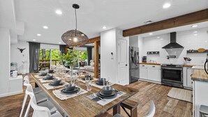 A modern kitchen with white cabinets, a black range hood, and a wooden countertop. - Dog-Friendly Pocono Chalet w/ Hot Tub, Indoor Pool (Long Pond)
