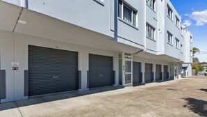 Fila de puertas de garaje cerradas con cielo despejado arriba.