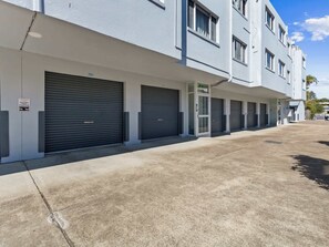 A row of closed garage doors with a clear sky above. - Spacious Hervey Bay Apartment with Rooftop Access (Torquay)