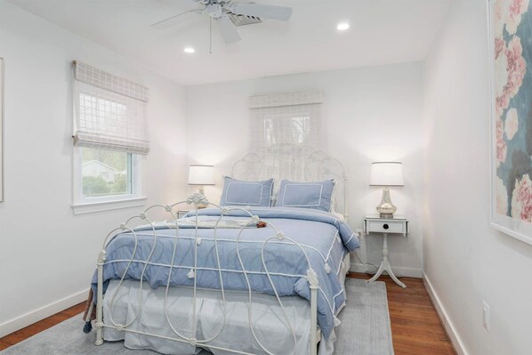 A bedroom with a bed, bedside tables, a ceiling fan, and a window with blinds. - Beautiful 3 Bedroom Retreat walking distance to Downtown St. Michaels (Saint Michaels)
