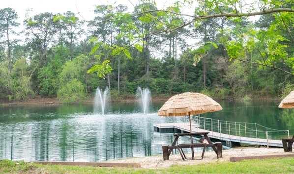 A tranquil lakeside setting with a wooden dock, a thatched umbrella, and a fountain. - Crosby Retreat (Crosby)