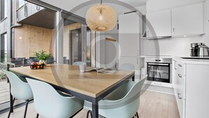A modern kitchen with white cabinets, a built-in oven, and a coffee maker. - Havnehusene, Lejl. 59 (Slagelse)