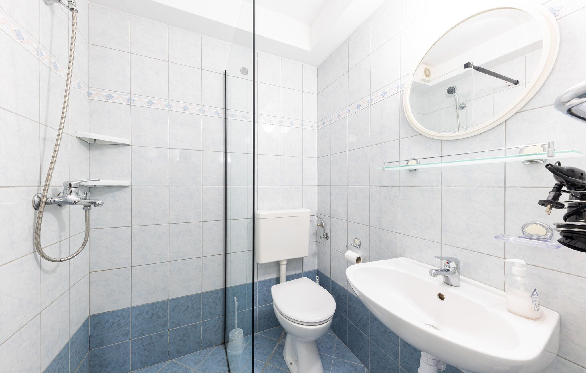 A modern bathroom with a shower, toilet, sink, and a glass-enclosed shower area.