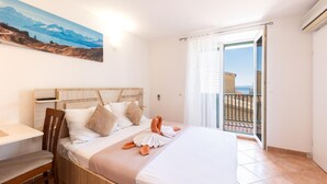 Ein Hotelzimmer mit Bett, Schreibtisch und einem Bild an der Wand.