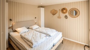 A bedroom with a bed, wall-mounted light fixtures, and decorative items.