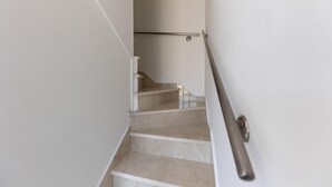 Un escalier avec une rampe, menant à un palier.