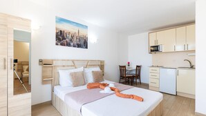 Une chambre d’hôtel équipée d’un lit, d’un bureau, d’une chaise, d’un four à micro-ondes et d’un lavabo.