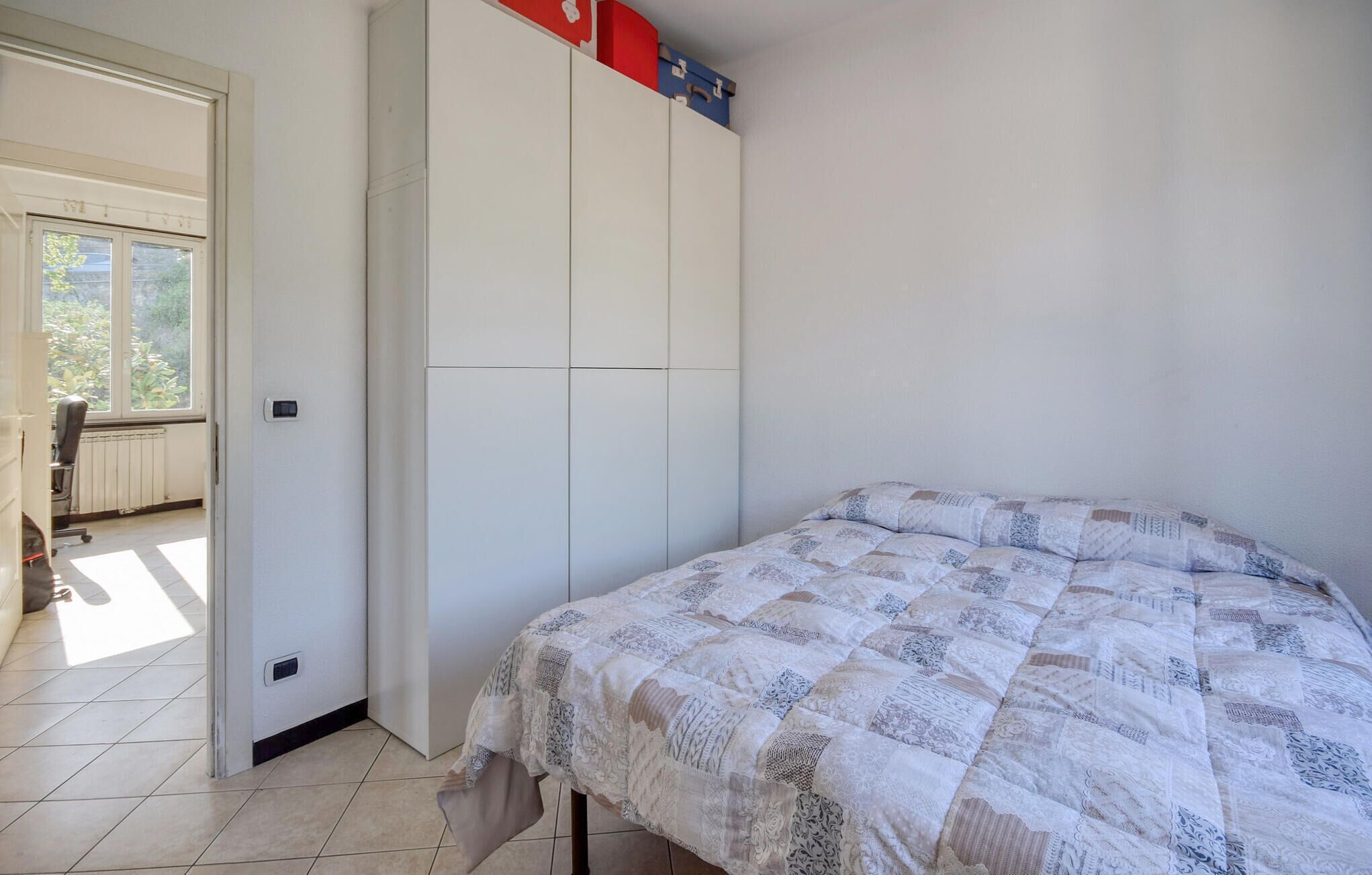A bedroom with a bed, a wardrobe, and a radiator.