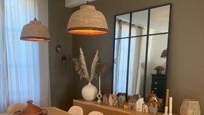 A modern dining area with a wooden table, white chairs, and pendant lights. - Double room with private bathroom (Senlis)