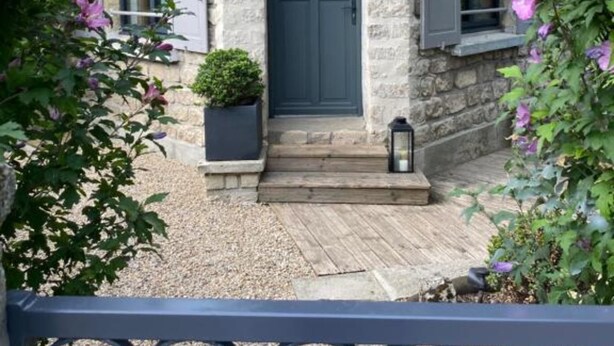 A stone house with a dark blue door, number 2, and a small garden with pink flowers. - Double room with private bathroom (Senlis)