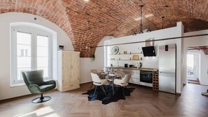 A spacious kitchen with a brick ceiling, modern appliances, and a dining area with a herringbone floor pattern.