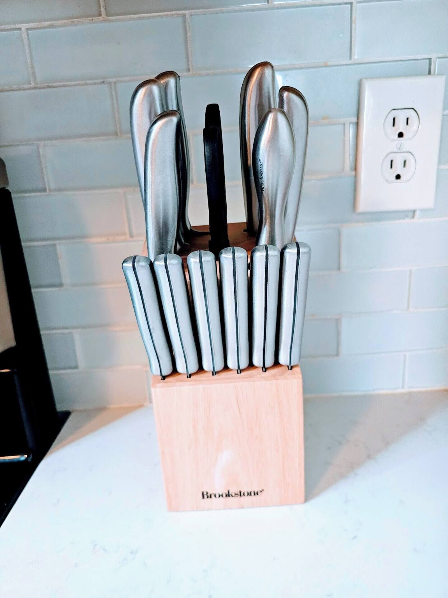 A kitchen knife block with multiple knives on a countertop.