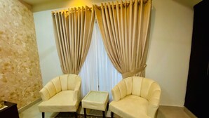 A room with two armchairs, a small table, and a patterned rug.