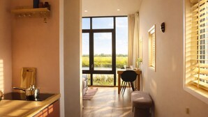 A kitchen with a large window, a dining area with a table and chairs, and a small stool. - Pean-buiten Weidum (Weidum)