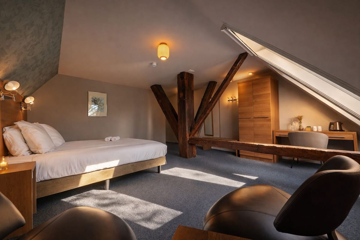 Ein Schlafzimmer mit einem Bett, Nachttischen, einem Schreibtisch und einem Stuhl.