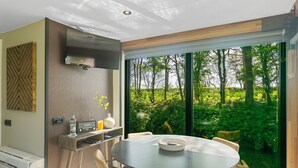 A modern dining area with a round table, chairs, and a built-in grill. - Pean-buiten Weidum (Weidum)