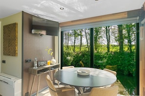 A modern dining area with a round table, chairs, and a built-in grill. - Pean-buiten Weidum (Weidum)