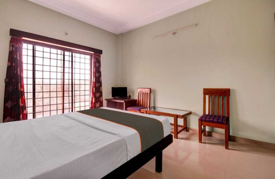 Une chambre à coucher comprenant un lit, un bureau, une chaise et un téléviseur.