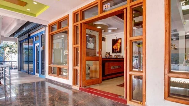 Zona de recepción con un mostrador de madera, puertas de vidrio y vistas al exterior.