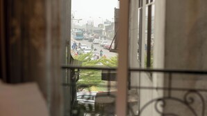 A view from a window overlooking a busy street with vehicles and pedestrians. - Hanoi Oldtown Boutique Hotel  (Hanoi)
