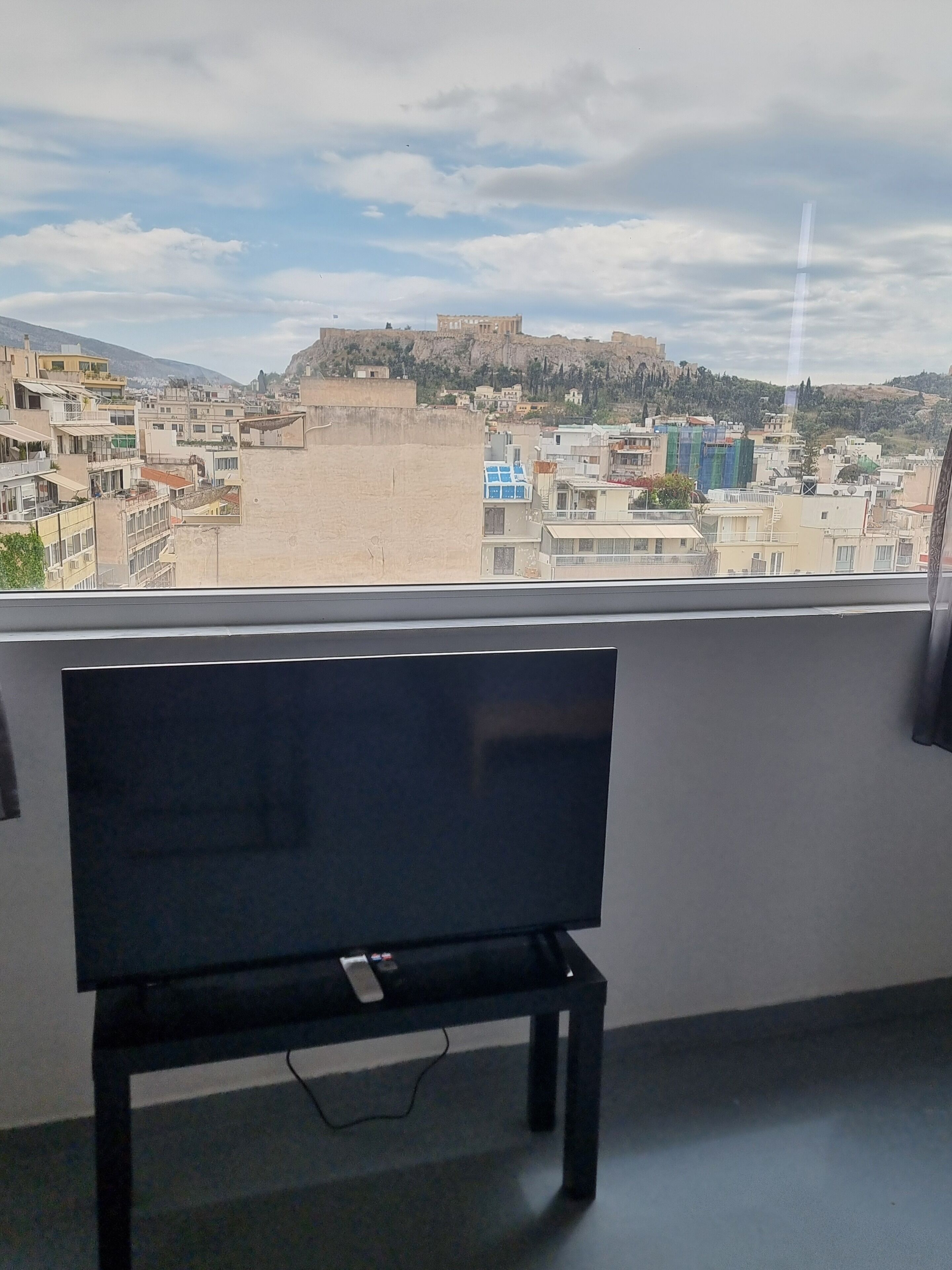 Ein Zimmer mit Blick auf eine Stadtlandschaft, darunter ein Hügel mit einer schlösserartigen Struktur.