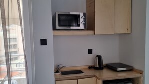 A compact kitchen with a microwave, a small refrigerator, and a sink. - athens parthenon view (Athens)