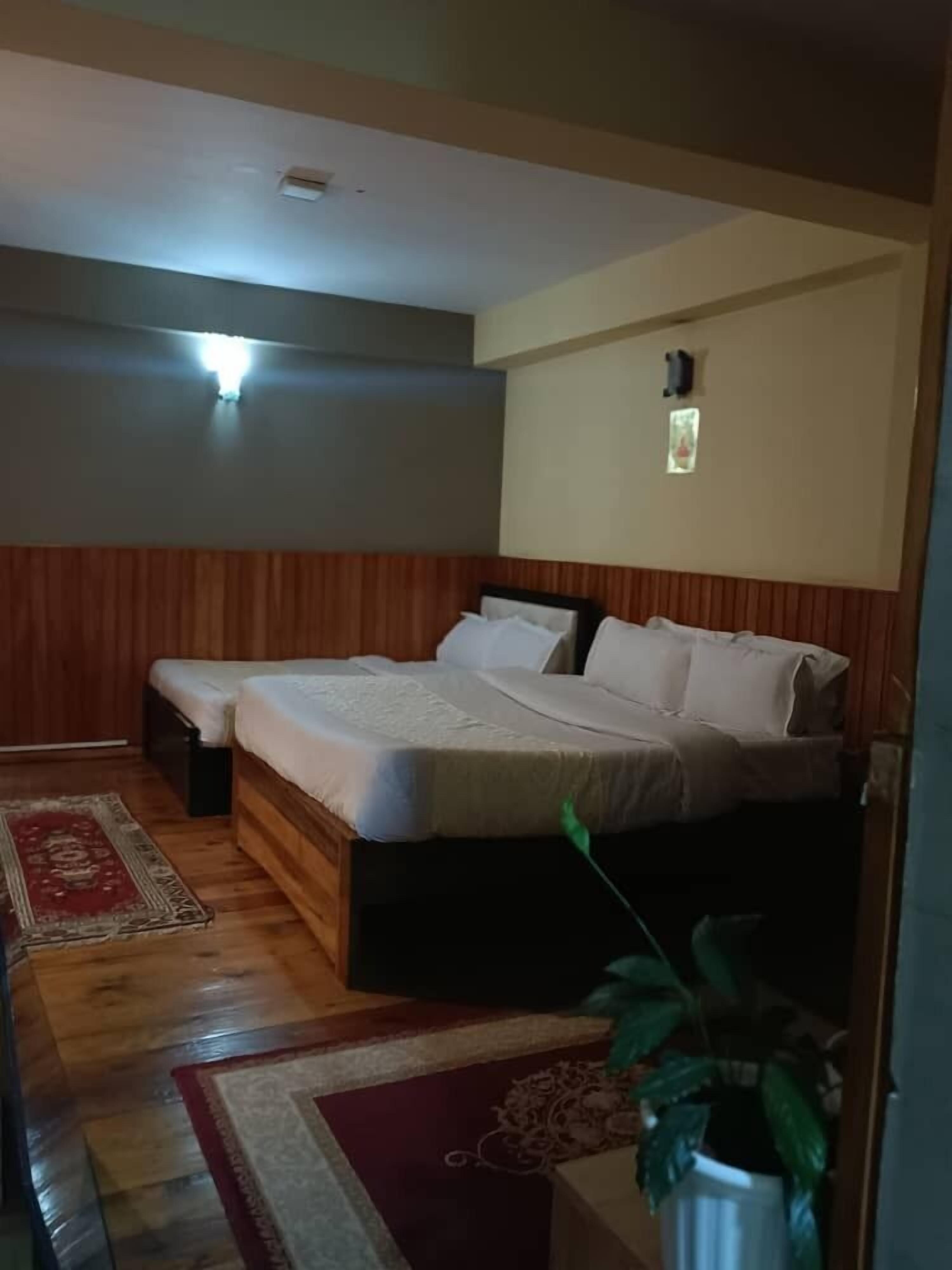 Una camera da letto con un letto, un comodino, una lampada a muro e una ventola a soffitto.