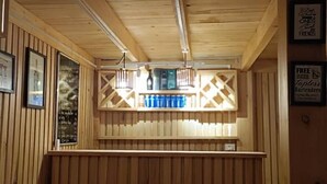 A wooden bar area with stools and a counter. - UV INN (Thimphu)
