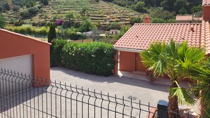 Un quartier résidentiel caractérisé par des champs en terrasses, un bâtiment à toit rouge et un palmier.