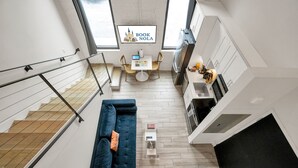 Un appartamento moderno con zona living, angolo cottura e una scala.