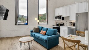 A compact living space with a sofa, a small round table, and a dining area. - Frenchmen St Gem • Walk to French Quarter (New Orleans)