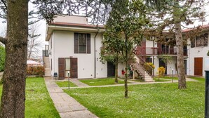 Un patio con un sendero que lleva a un edificio con balcón.