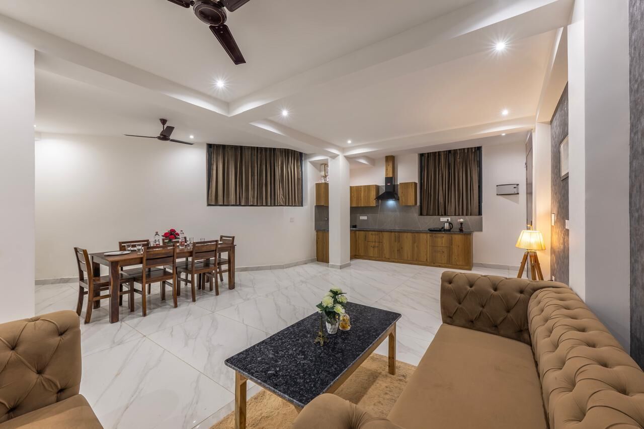 Una sala de estar moderna con comedor, cocina y zona de estar con sofá y mesa baja.