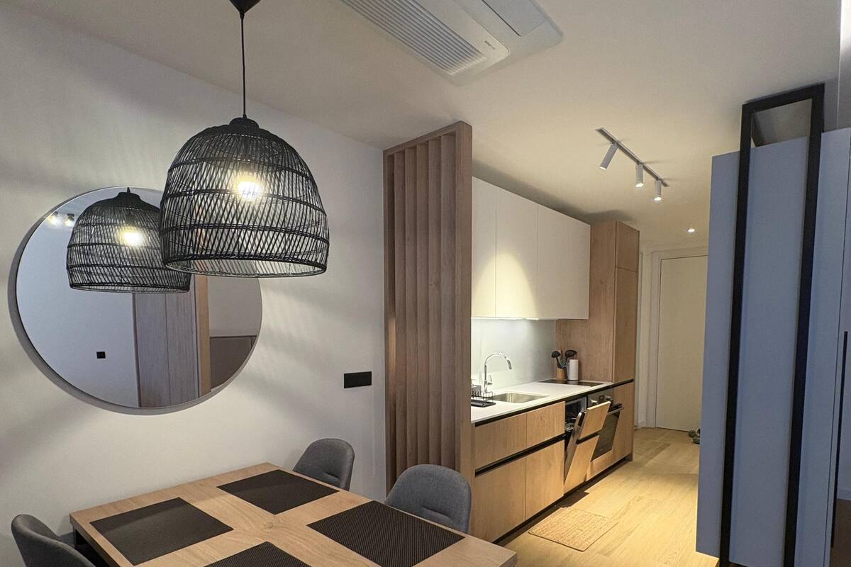 A modern kitchen with wooden cabinets, a built-in oven, and a sink.