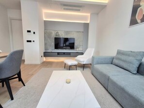 Apartament de luxe, balcó, vistes a la ciutat | Sala d'estar | Televisor LCD de 45 polzades amb canals digitals 