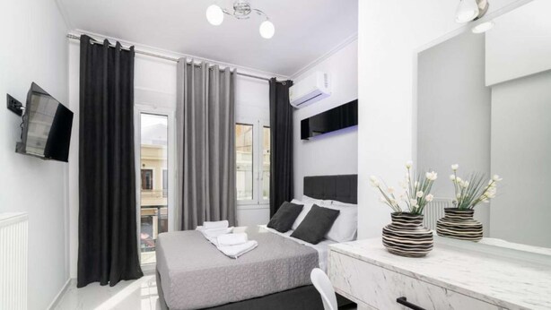 Une chambre à coucher moderne avec un lit, un bureau et un miroir.