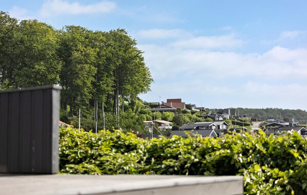 Een woonwijk met huizen en een grote boom op de voorgrond.