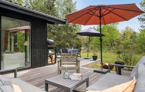 A deck with outdoor furniture, a grill, and a large umbrella. - 3 bedroom gorgeous home in Højby (Højby)