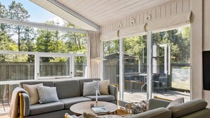 Una habitación soleada con sofá, una mesa redonda y televisor.