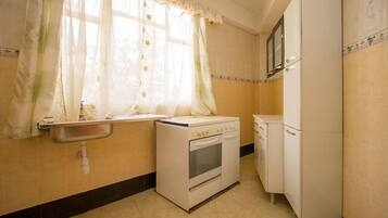 A compact kitchen with a sink, stove, and refrigerator.