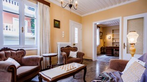 Een woonkamer met twee bruine leren banken, een houten salontafel en een gebreid plaid.
