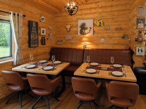 A wooden cabin interior with a dining area featuring two tables, four chairs, and a bench. - Scandinavian Luxury Log Cabin Sleeps 6, Hot Tub, Durham & Bishop Auckland (Oakenshaw, Durham)