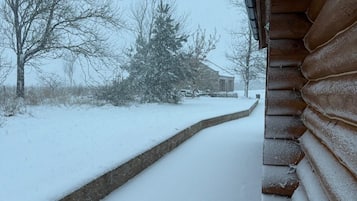 A snowy landscape with a wooden cabin and a snow-covered path leading to it.