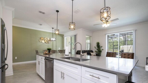 A modern kitchen with white cabinetry, a large island, stainless steel appliances, pendant lighting, and a view to the dining area. - Storey Lake Resort, Private Pool, Near Famous Attractions!! (Kissimmee)